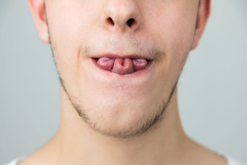 Person rolling their tongue, into a clover leaf.