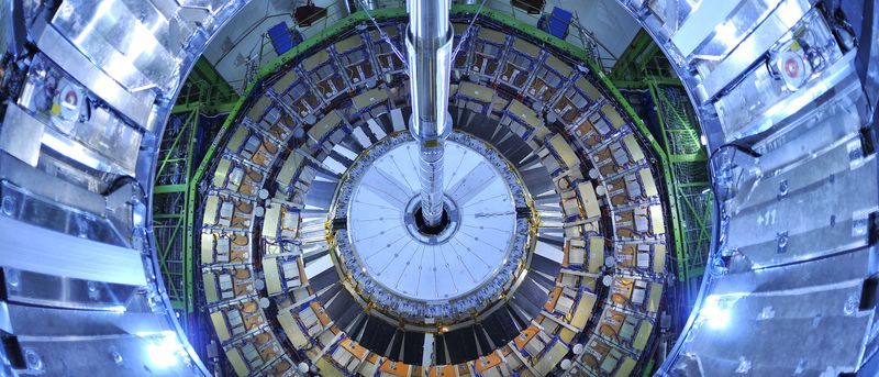 Photograph of the Large Hadron Collider, blue-tinged concentric rings of metallic sheets with a metal pole in the middle