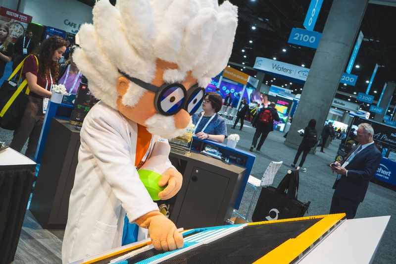 Person in a scientist costume holding a beaker over lego 