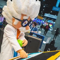 Person in a scientist costume holding a beaker over lego 