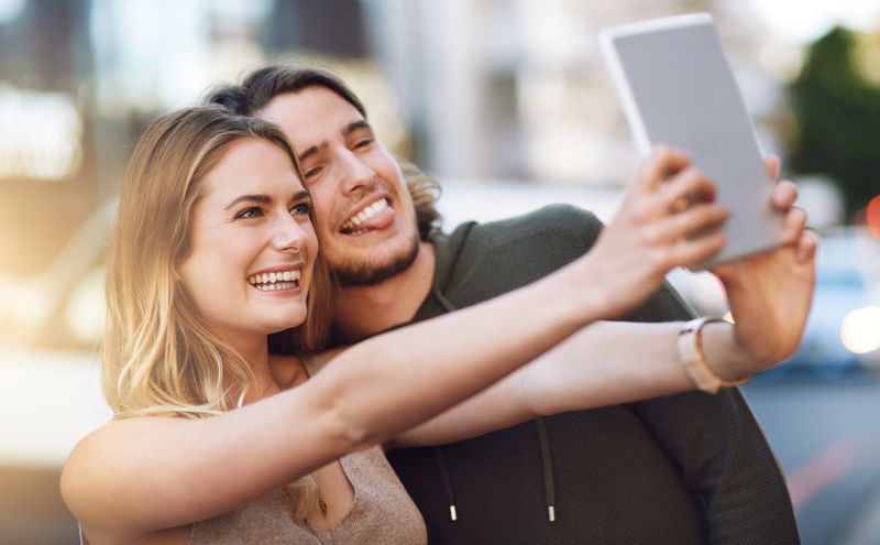 couple taking a selfie with a tablet