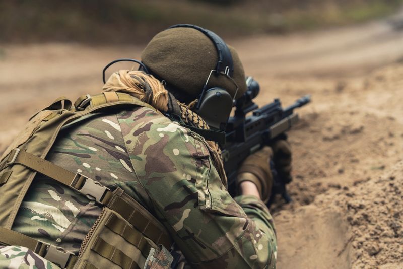 soldier with back to camera holding weapon guarding territory