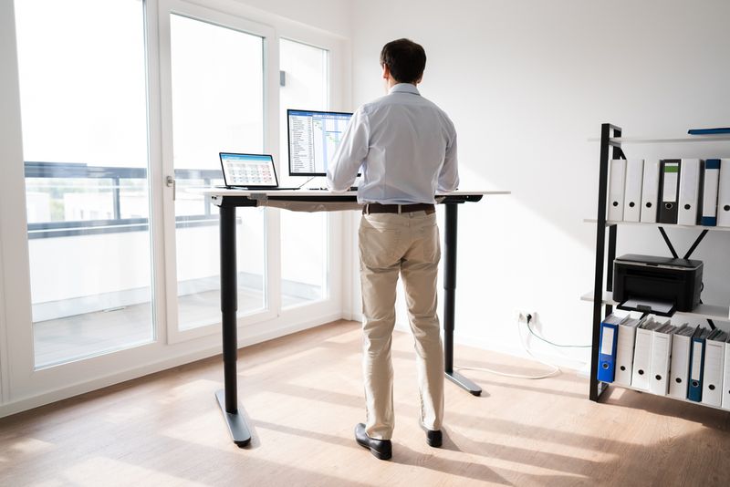 A man standing at his desk and working.