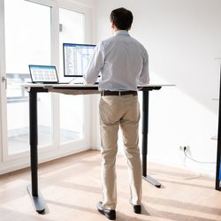 A man standing at his desk and working.