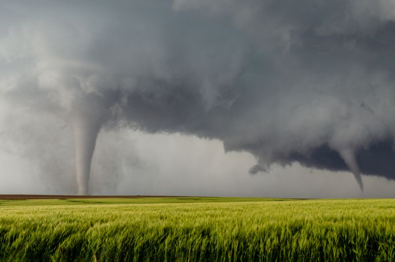 two tornadoes in an open field