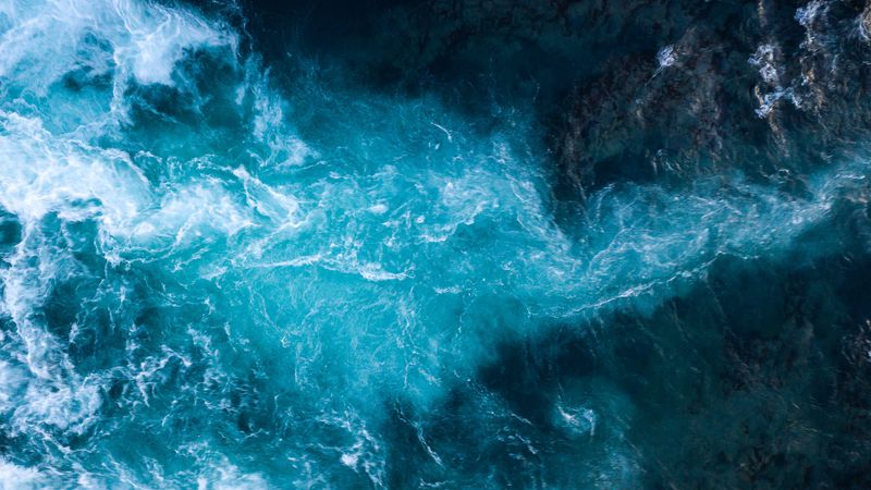 Aerial view of Atlantic ocean waves washing black basaltic sand beach in Iceland