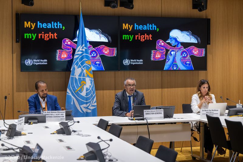 The first meeting of the Emergency Committee (EC) convened by the WHO Director-General under the International Health Regulations (2005) (IHR) regarding the upsurge of mpox 2024 took place on 14 August 2024. Photo show three WHO committee members sitting at a table with a WHO flag and two screens behind them