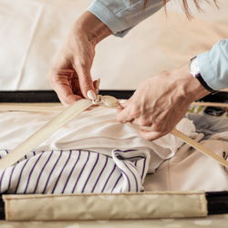 woman unpacking suitcase on bed after holiday