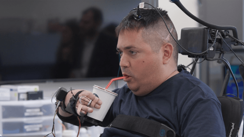 Keith Thomas lifts and drinks from a cup on his own thanks to a brain implant that is helping him to overcome paralysis caused by an injury.