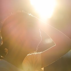 Silloute of a woman Infront of hot weather with sun flare due to climate change