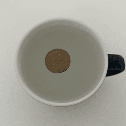 Cup with frozen water and a coin on top. 