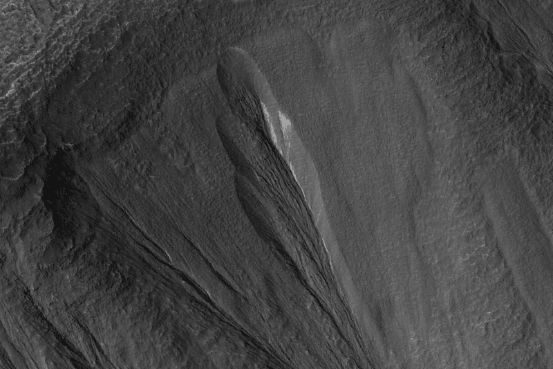 A gully in the Martian region Dao Vallis photographed by the Mars Reconnaissance Orbiter. White areas are thought to be dusty ice deposits.