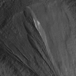 A gully in the Martian region Dao Vallis photographed by the Mars Reconnaissance Orbiter. White areas are thought to be dusty ice deposits.