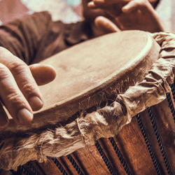 Male hands playing a traditional percussion drum musical instrument.