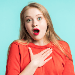 a woman shocked, someone made her jump, she is surprised and holding her chest