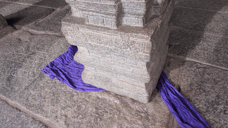 A pillar with a cloth underneath most of it.