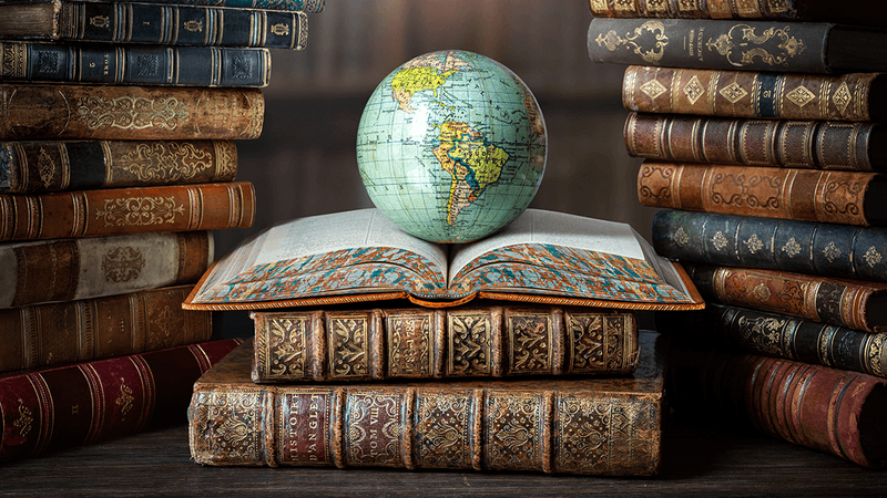 A globe on top of a pile of books.