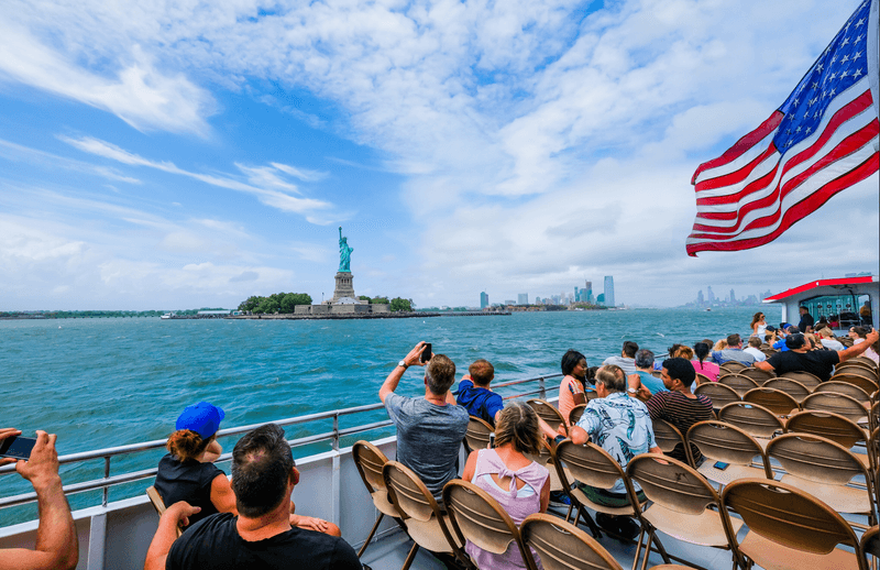  Cruises ferry carrying tourists front of the Statue of Liberty in New York City, USA