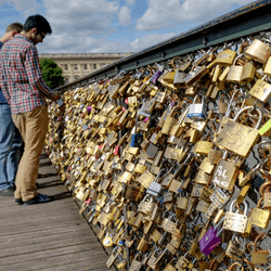 love lock bridge in paris with lots of padlocks attached to the fence