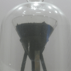 A funnel containing pitch, inside a larger display jar.