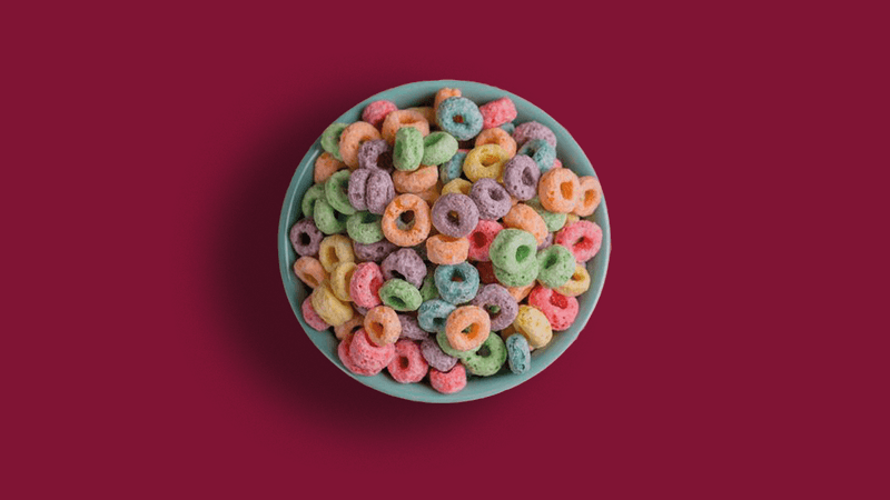 A bowl of colourful cereal clearly dyed using food dyes to appeal to children