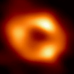 The event horizon telescope image of our galaxy's supermassive black hole, Sagittarius A*. An orange donut with some brighter spots is seen around a dark center where the black hole is