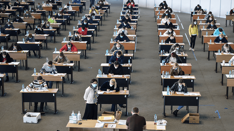 Students sitting exams in a large room.