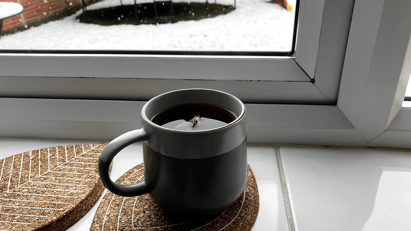 A mug of tea on a windowsill.