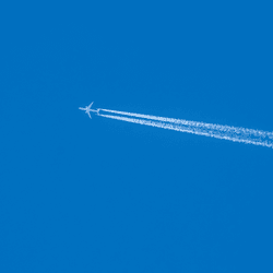 a plane leaving a white trail behind in a blue sky