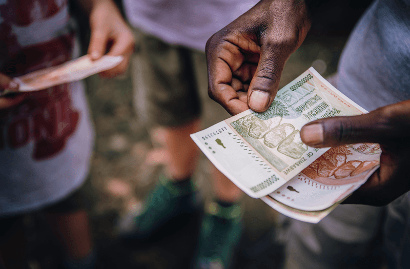 Man counting Zimbabwean dollar’s in Victoria Falls, Zimbabwe